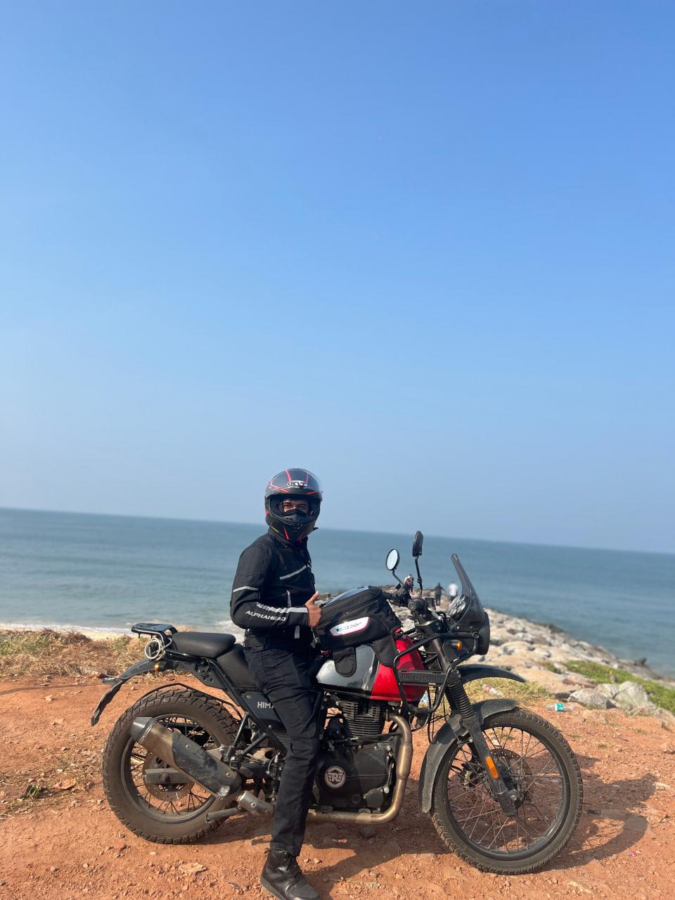 Me beside beside my Royal Enfield Himalayan overlooking the sea