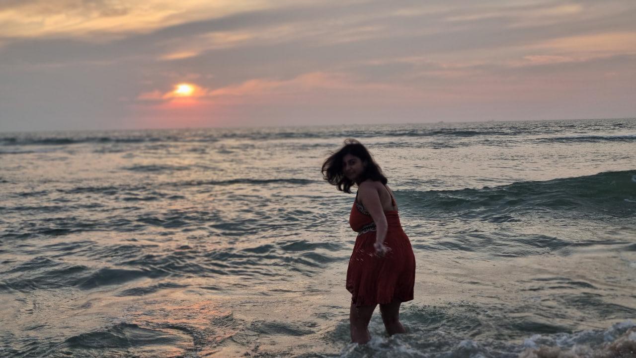 Ruchita standing in the surf at sunset